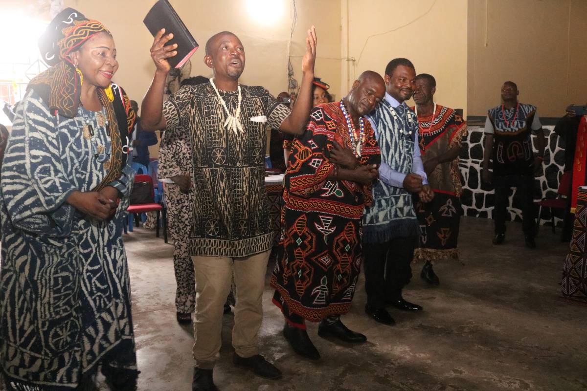 Isu man smiling and looking up to God while holding up New Testament